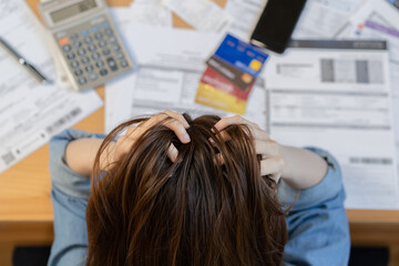 Naklejka premium Financial owe asian young woman, girl sitting suffer, stressed and confused by calculate expense from invoice or bill, have no money to pay, mortgage or loan. Debt, bankruptcy or bankruptcy concept.