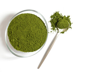 Chlorella green powder in a bowl and spoon isolated on a white background. Barley or spirulina powder. Superfood. Copy space, top view