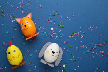 Easter holiday concept with cute handmade eggs, dogs, cat and chicks on blue background.