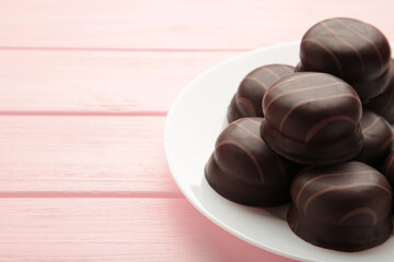 Chocolate sweets on a pink wooden background. Biscuit