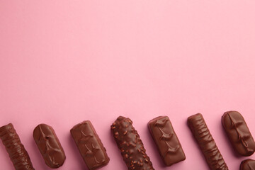 Mix of chocolate bars on pink background with copy space. Top view. © Mouse family