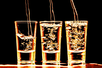 Vodka shots in a row. Neon bar encounter. Illuminated transparent glass. Pouring liquor. Weekend party alcohol background.	Golden color vodka party.
