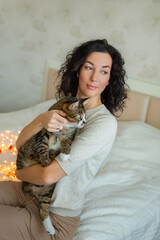 Young beautiful woman with cute cat resting at home. Domestic pet concept.