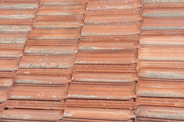 A horizontal texture of part of an old brown roof of clay tiles