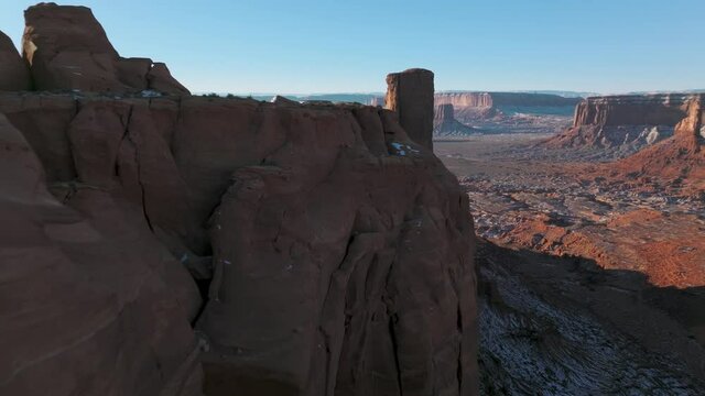 4K aerial background of extreme sport and leisure recreation, mountain climbing in scenic wilderness. Drone flying fast low above high red cliffs buttes in Monument valley in Arizona, Utah tourism USA