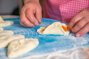 mom makes pies with carrots out of dough. High quality photo