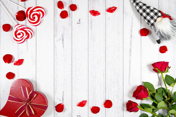 Valentine's Day farmhouse theme framed border background styled with red roses, heart gift, and buffalo plaid gnome against a white wood background. Creative composition flat lay backgroud.
