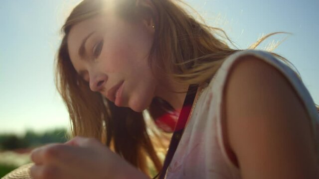 Serious woman working with camera outdoors. Thoughtful woman checking device. 