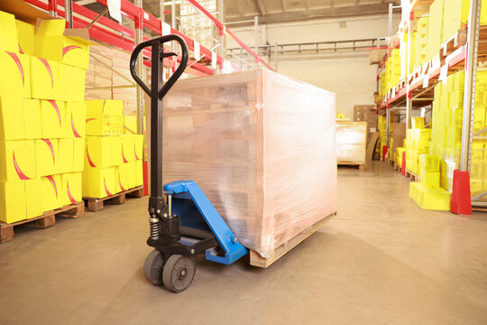 Wooden Pallets Wrapped In Stretch On Manual Forklift Indoors