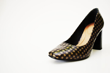 Fototapeta premium Zapato de tacón alto café y negro. Zapato para mujer sobre un fondo blanco, espacio para texto al lado izquierdo.