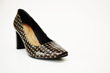 Zapato de tacón alto café y negro. Zapato para mujer sobre un fondo blanco, espacio para texto al lado derecho.