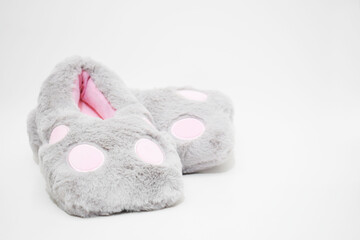 Pantuflas de peluche grises y rosadas. Pantuflas para mujer sobre un fondo blanco, espacio para...
