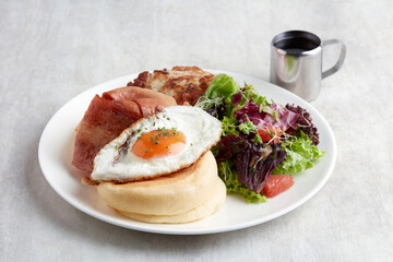 Kiseki Pancake with Maple Bacon and Fried Egg in white plate on grey background