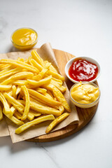 Overhead view of potatoes fries and cheese and ketchup sauces