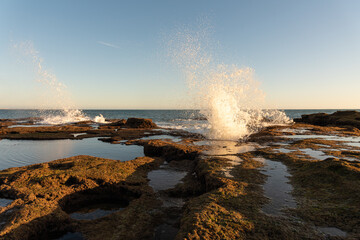 Waves crash over the rocks at Cadiz Bay at sunset, Andalusia, Spain
