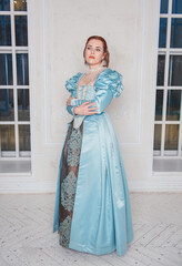 Beautiful young woman in medieval style blue dress