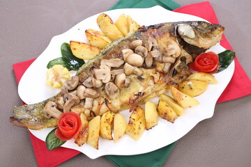 Roasted Carp fish with potatoes and mushrooms