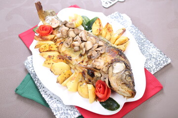 Roasted Carp fish with potatoes and mushrooms