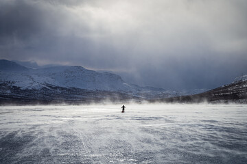 Cross country skier with sled (pulka) on a frozen river in in national park Sarek. Lapland, Sweden.