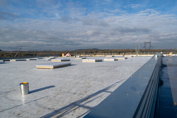 Construction of a flat roof with EPDM (ethylene propylene diene monomer) membrane on a large warehouse - obrazy, fototapety, plakaty