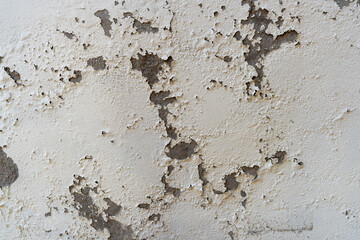 Old wall with cracked damaged white paint close up