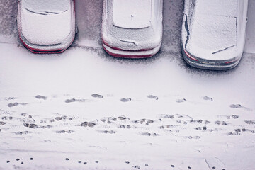 Fototapeta na wymiar Cars covered with snow parked in the yard of residential apartments house