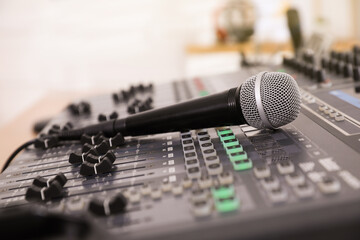 Microphone on professional mixing console in modern radio studio, closeup