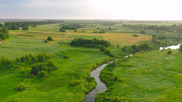 Aerial drone view of winding river in greenfield. Lush wetlands of bird's eye view. Discover the beauty of earth