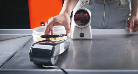 Customer paying for purchases contactless with smartphone.