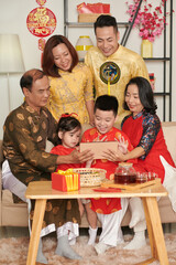 Happy family in traditional ao dai dresses video calling friends and family member to wis happy happy Lunar New Year - obrazy, fototapety, plakaty