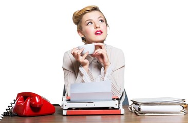 Retro woman working in office with vintage typewriter and phone, dressed in pin-up style