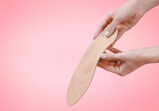 Orthopedic insole isolated on a pink background. Medical insoles. Treatment and prevention of flat feet and foot diseases. Foot care, feet comfort. Wear comfortable shoes. Flat Feet Correction.