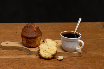 Muffin and white cup with coffee on the table. Cup of coffee and muffins for breakfast.