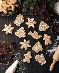 Overhead of Christmas shaped gingerbread cookies on black table.