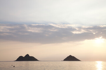 Fototapeta na wymiar The Mokulua Islands at Sunrise under Cloud Cover, Lanikai, O'ahu