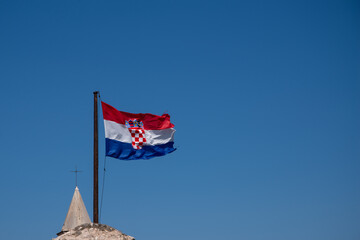 Croatian flag flies in the wind, blue summer sky as background - obrazy, fototapety, plakaty