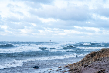 Fototapeta na wymiar Stormy weather by the sea in Riga, Latvia. Huge waves crashing down the coast of Latvia.