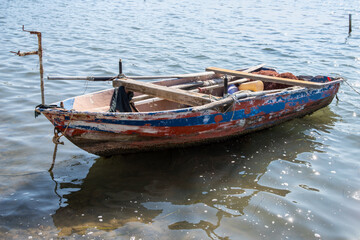 Very old and weathered, wooden fisher boat on the water