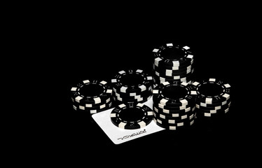 Black сhips and joker card on the table in the casino. Fortune or success in the game of poker