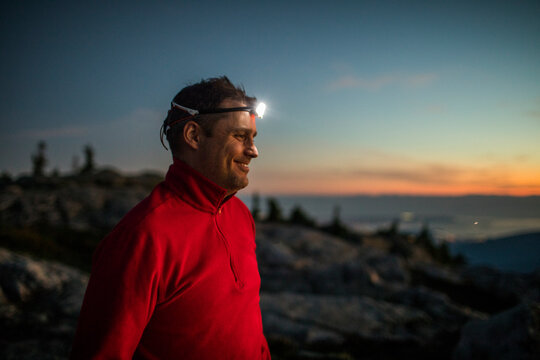 Portrait of active smiling man wearing headlamp while trail running. - Powered by Adobe