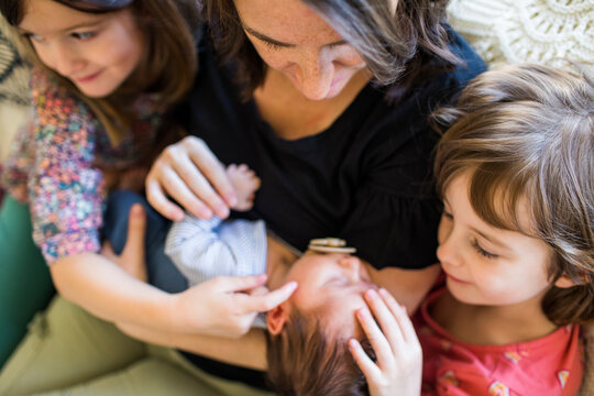 Mom and big sisters swoon over new baby brother