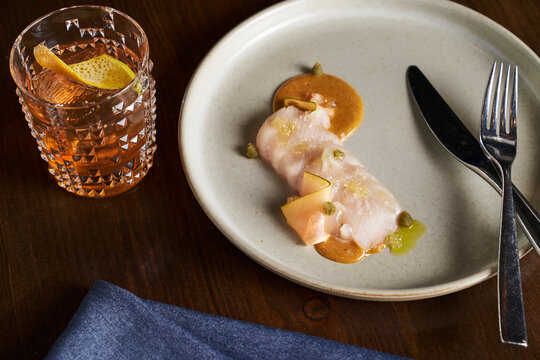 Hamachi crudo with a caper citrus sauce and whiskey old fashioned.
