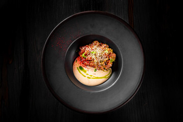 Raw beef meat tartar in black plate 