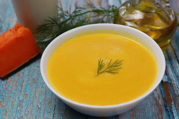 Pumpkin soup. Front view on rustic blue wooden table.