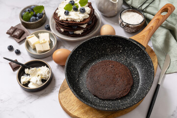 Healthy breakfast. Ingredients for cooking and delicious crepes with blueberries and ricotta on a marble tabletop.