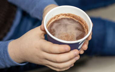 chocolate. child drinks from paper cup, cardboard, eco. brunette kid, profile view. portret. modern car interior. drinks from coffee machine.