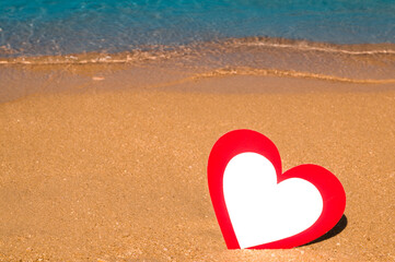 Paper card heart shaped in the sand on the beach.St valentine's in tropics. Banner with place for text