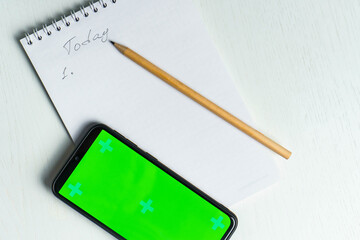 White notepad with inscription today, smartphone green screen mockup and pencil flat lay. Tamplate for design