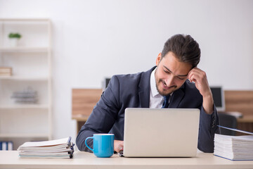 Young male employee sitting at workplace