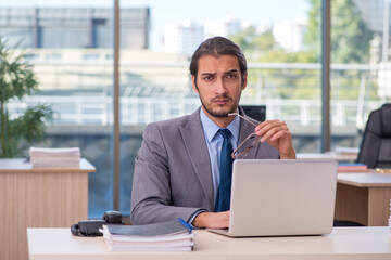 Fototapeta premium Young male employee in wheel-chair working in the office